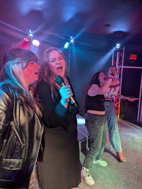 Friends singing karaoke together on stage